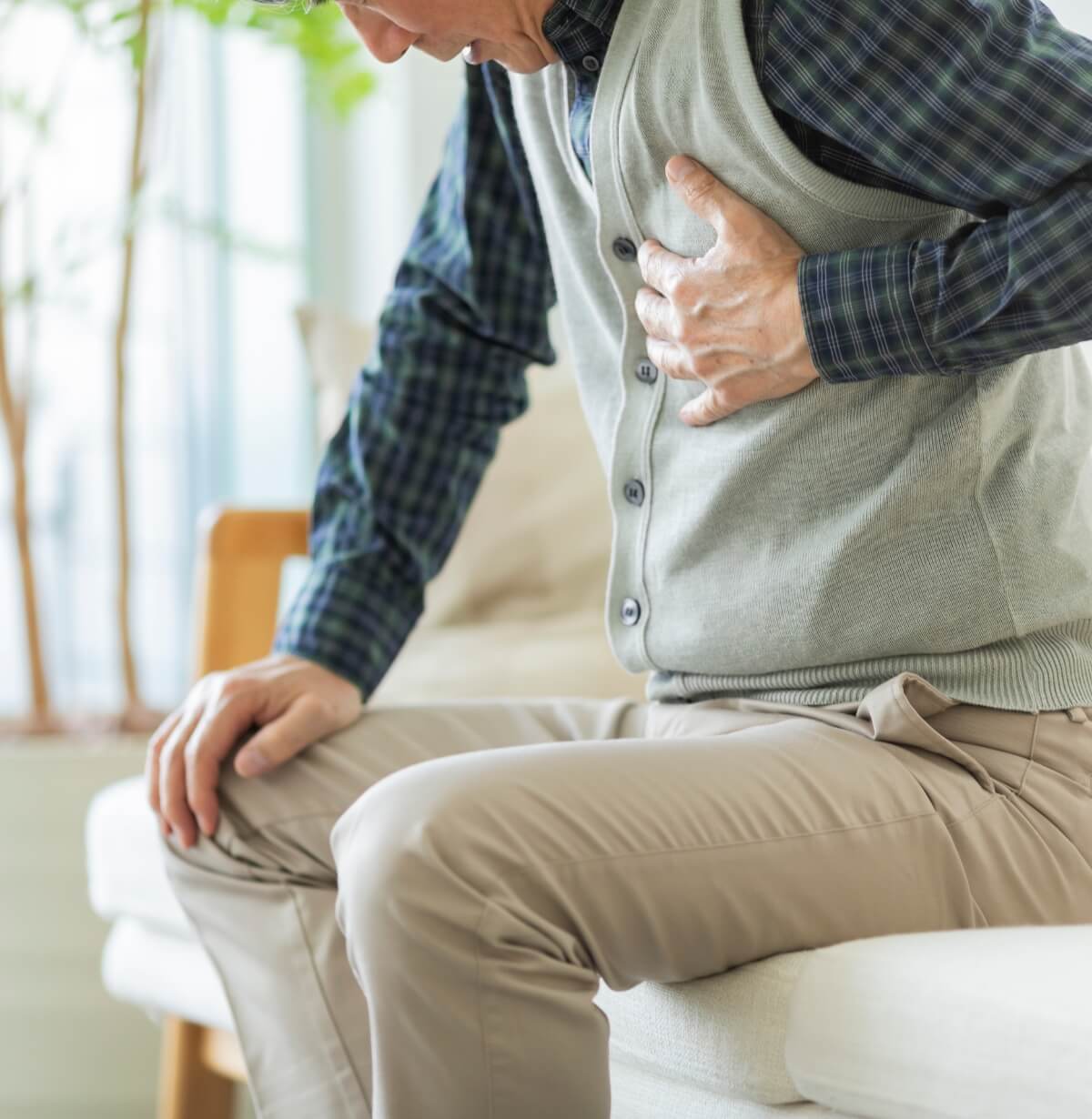 心臓を痛そうに手でおさえている男性